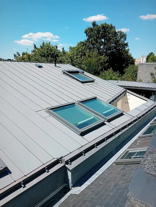 Toiture en pente recouverte de bacs acier jointifs de couleur gris anthracite, vue en plongée