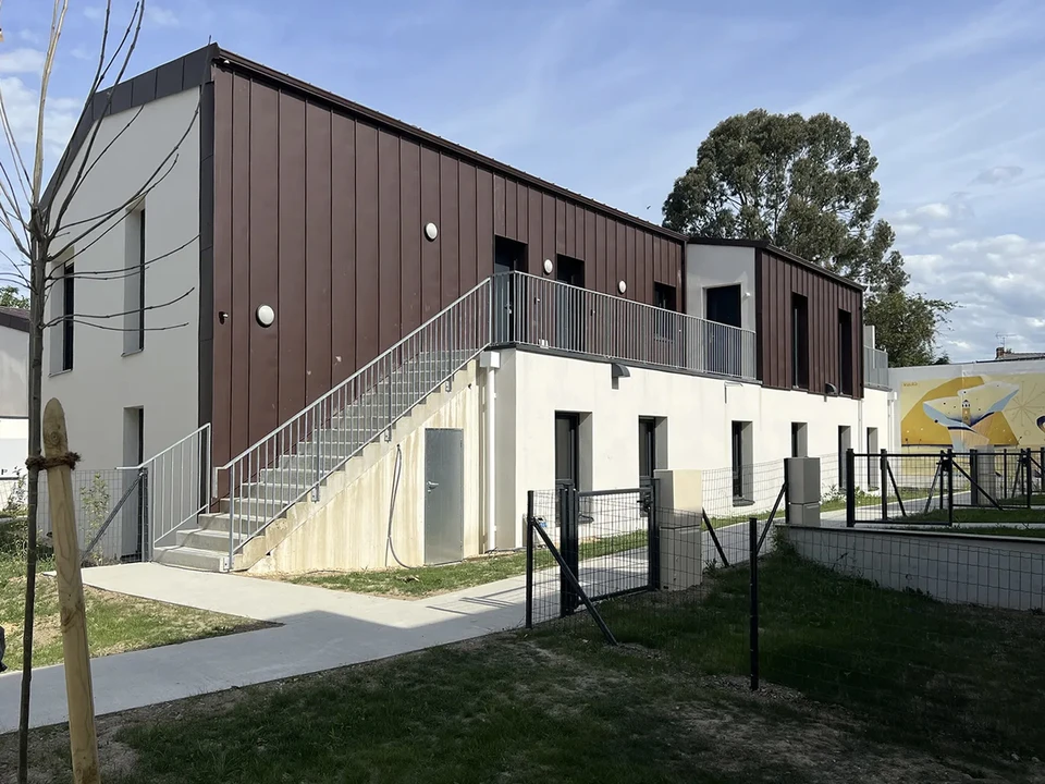 Maison contemporaine à architecture moderne avec façade blanche, toiture métallique anthracite et éléments en bois
