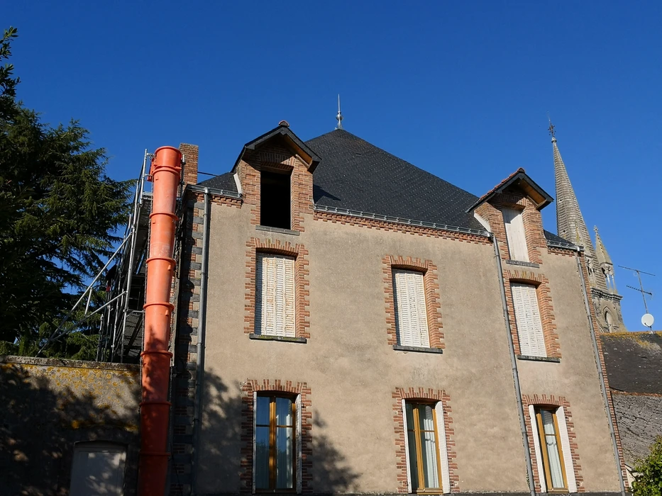 Scène extérieure, ardoisier taillant une ardoise naturelle à la main