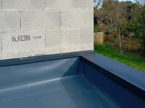 Toit terrasse d'un bâtiment commercial avec lanterneau vitré rectangulaire installé sur membrane d'étanchéité blanche