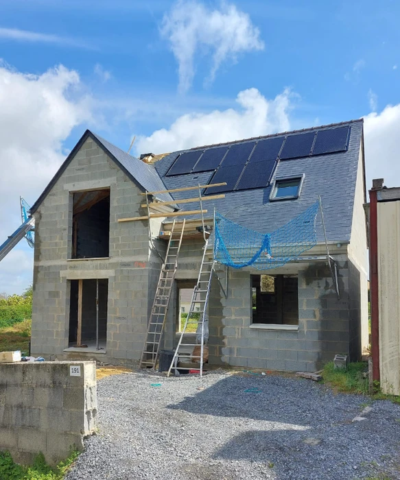Toiture terrasse avec membrane EPDM grise, équipée de panneaux solaires photovoltaïques monocristallins noirs, montés sur ballasts d'inclinaison fixes