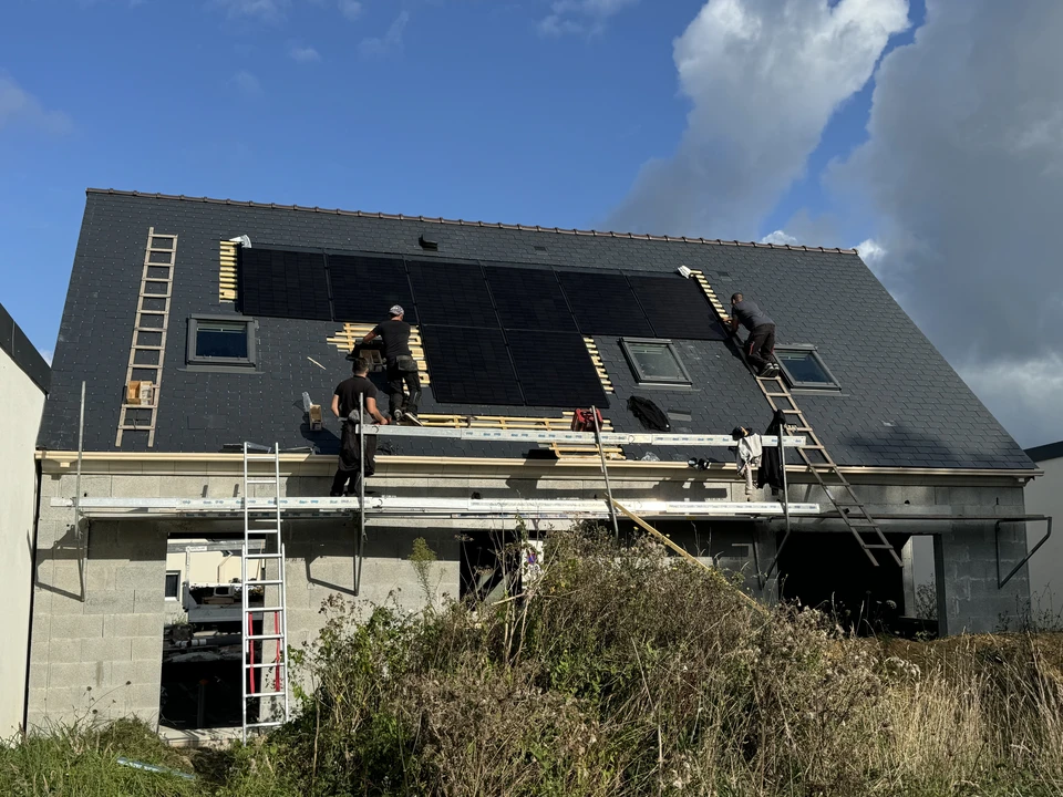 Toiture résidentielle extérieure avec couverture en ardoises grises sous ciel nuageux