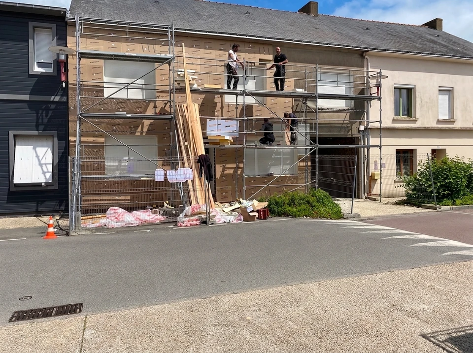 Façade rénovée d'un bâtiment résidentiel à bardage métallique vertical gris anthracite, pose en joint debout