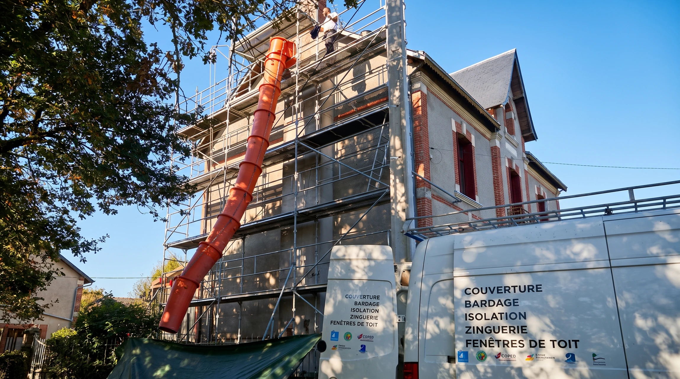 Maison individuelle moderne avec façade vert clair et soubassement brun, toiture tuiles brunes, fenêtres à encadrements rouges